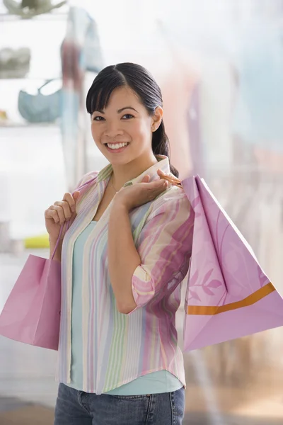 Chinese woman holding shopping bags — Stock Photo #13225141