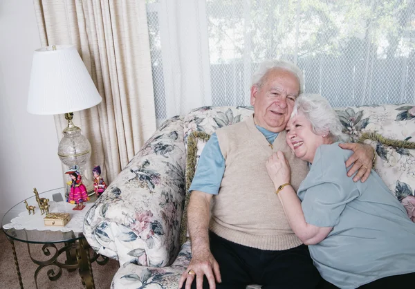 Senior couple hugging on sofa