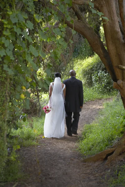 Newlyweds walking along dirt path