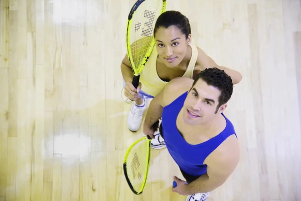 High angle view of man and woman with Squash rackets