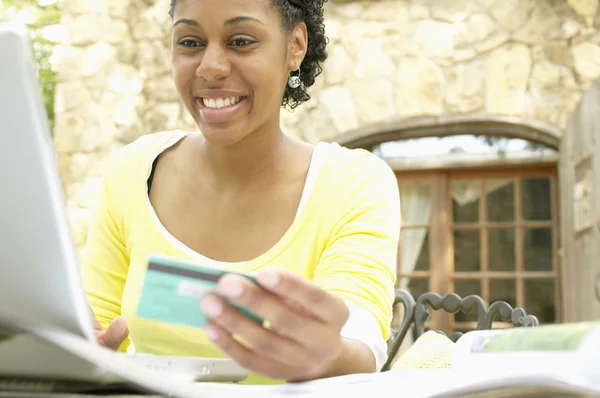 Woman ordering online with credit card and laptop