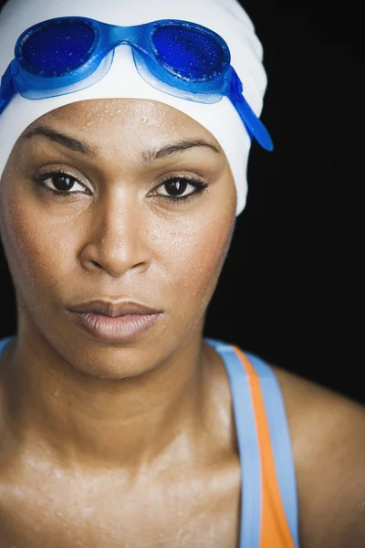 African woman wearing swimming cap and goggles