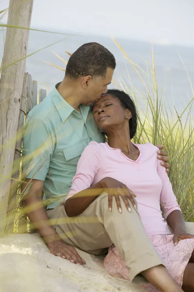 Middle-aged African couple hugging on beach