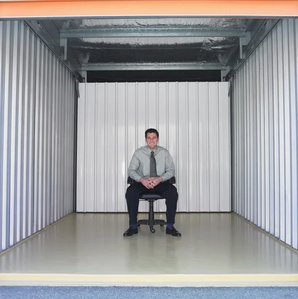 Businessman sitting in empty storage space