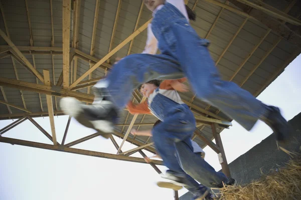 Low angle view of children jumping in hay