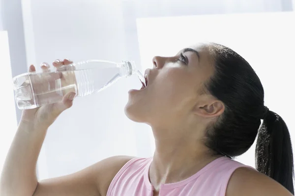 Teen girl drinking from water bottle