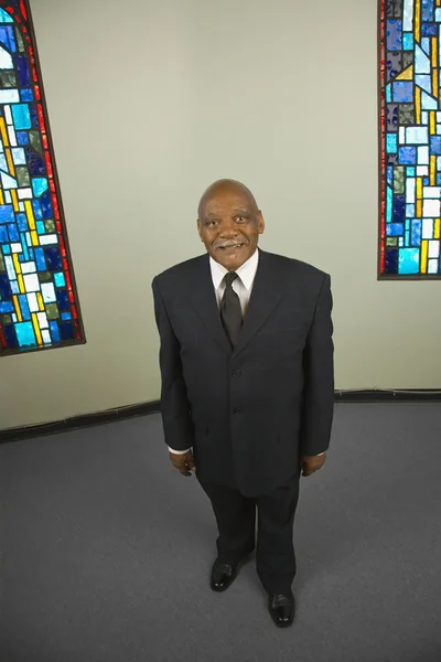 High angle view of senior African man next to stained glass windows