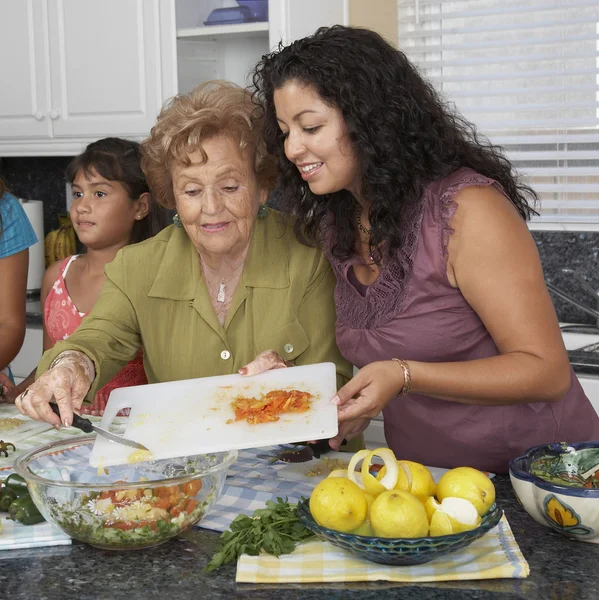 Multi-generational Hispanic female family members preparing food