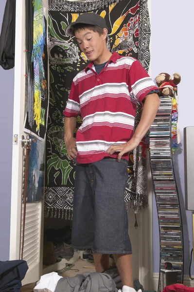 Teenage boy in messy bedroom
