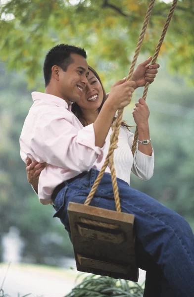 Young Asian couple on swing