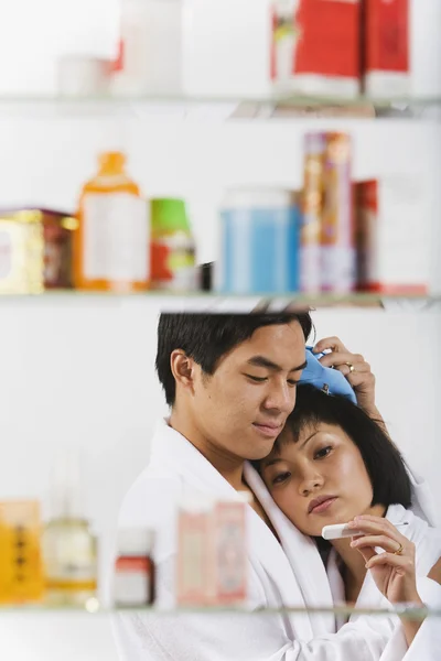 Portrait of sick Asian woman through medicine cabinet