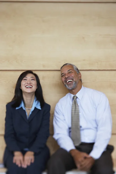 Two co-workers sitting and laughing