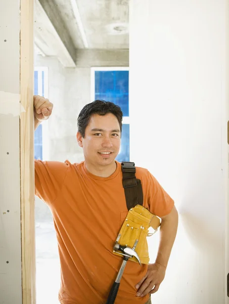 Male carpenter standing in doorway inside construction site