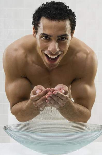Mixed Race man washing face