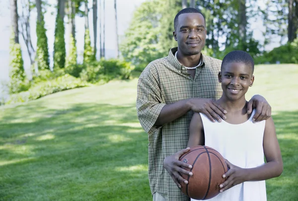 Portrait of father and son with basketball