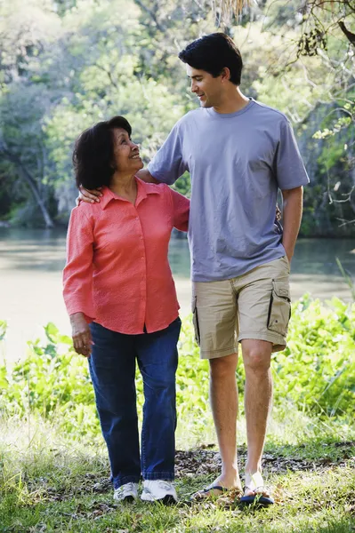 Hispanic mother and adult son walking outdoors