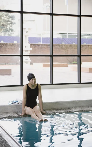 Female Asian swimmer with legs in pool