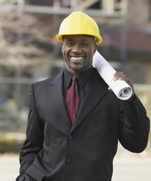 African American businessman holding blueprints