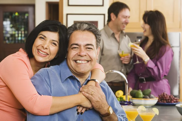 Middle-aged Hispanic couple hugging at party
