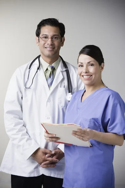 Portrait of Hispanic male doctor and nurse holding file
