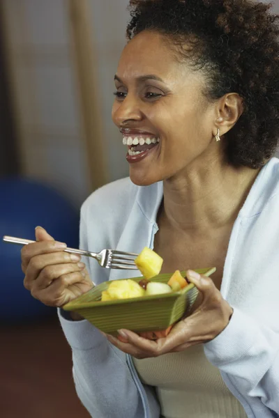 African woman eating fruit