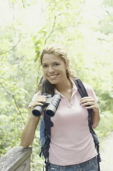 Young female hiker using binoculars