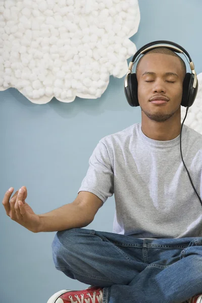 African man meditating and wearing headphones