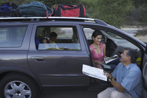Man examining map by his family minivan