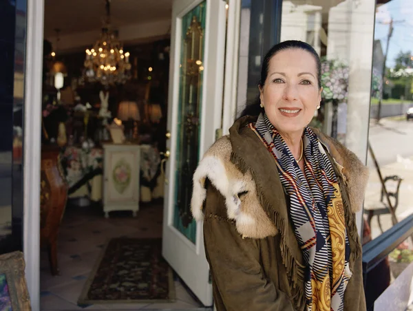 Middle-aged woman standing in front of antique shop