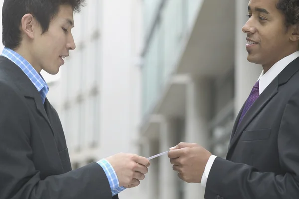 Profile of businessmen exchanging cards