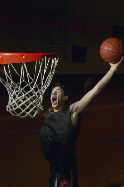 Basketball player about to slam dunk the ball