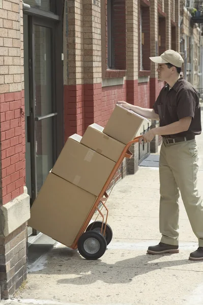 Side view of delivery man with boxes