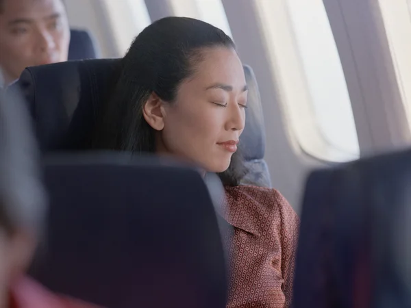 Young woman sleeping on airplane
