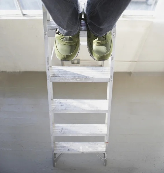 High angle view of man's feet on ladder