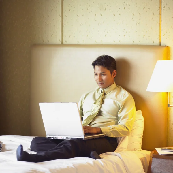 Businessman working on laptop in hotel room