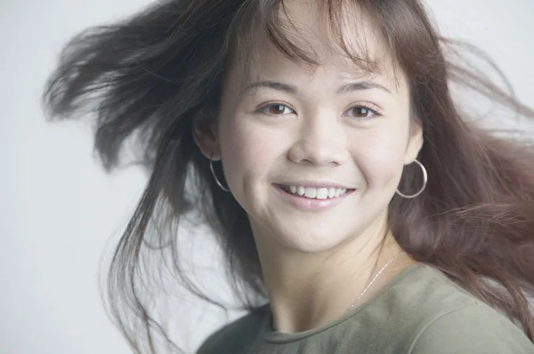 Asian woman smiling with hair blowing