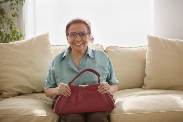 Portrait of elderly woman sitting on couch