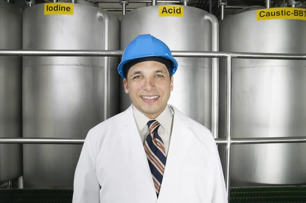 Portrait of man wearing hardhat and lab coat