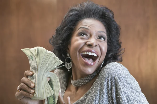 Close up of African American woman holding stack of 100 dollar bills