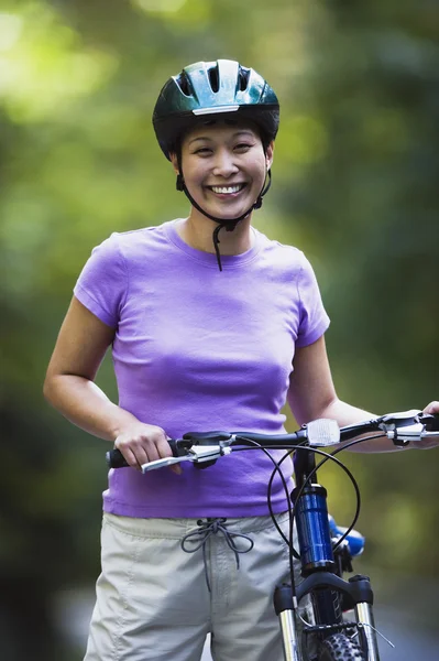 Portrait of woman with bike wearing bike helmet