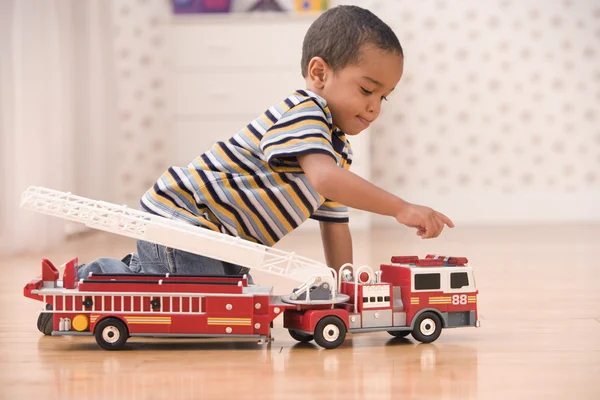 Young boy playing with fire truck