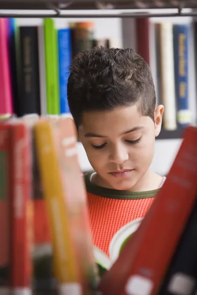 Young boy reading in library