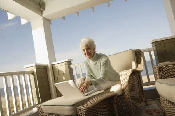 Senior woman using a laptop on the porch
