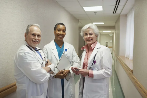 Three doctors standing in hospital hallway