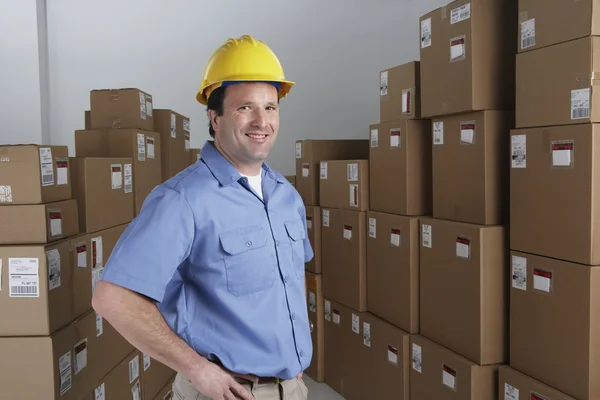 Male warehouse worker wearing hard hat in warehouse