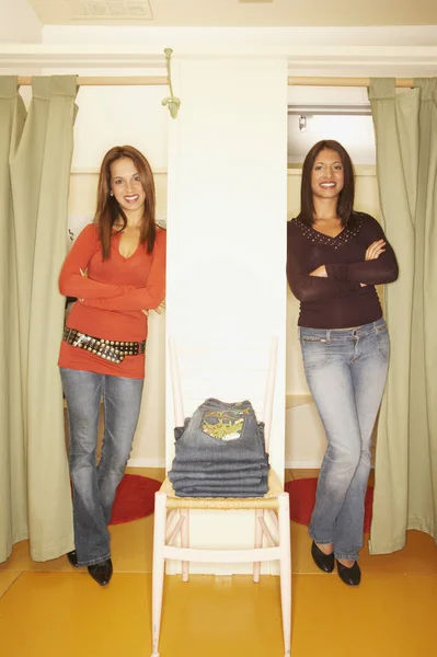 Two women standing in two fitting room doorways