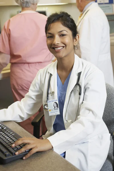 Young Indian female doctor at computer