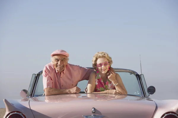Senior couple in a pink convertible