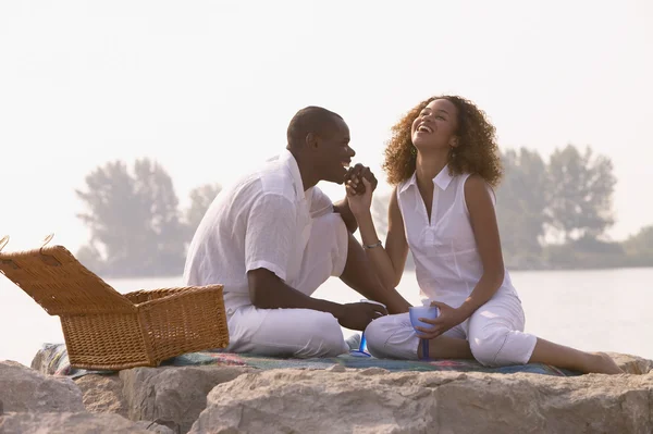 African couple having picnic on rocks