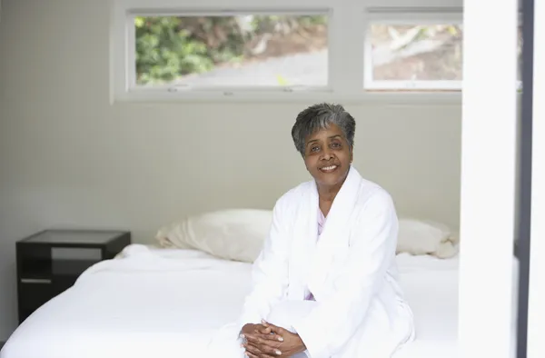 Senior African woman sitting on bed
